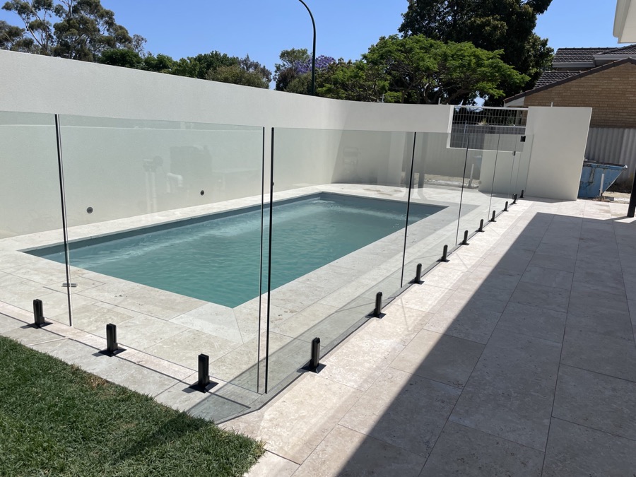 Frameless glass pool fence with black fittings